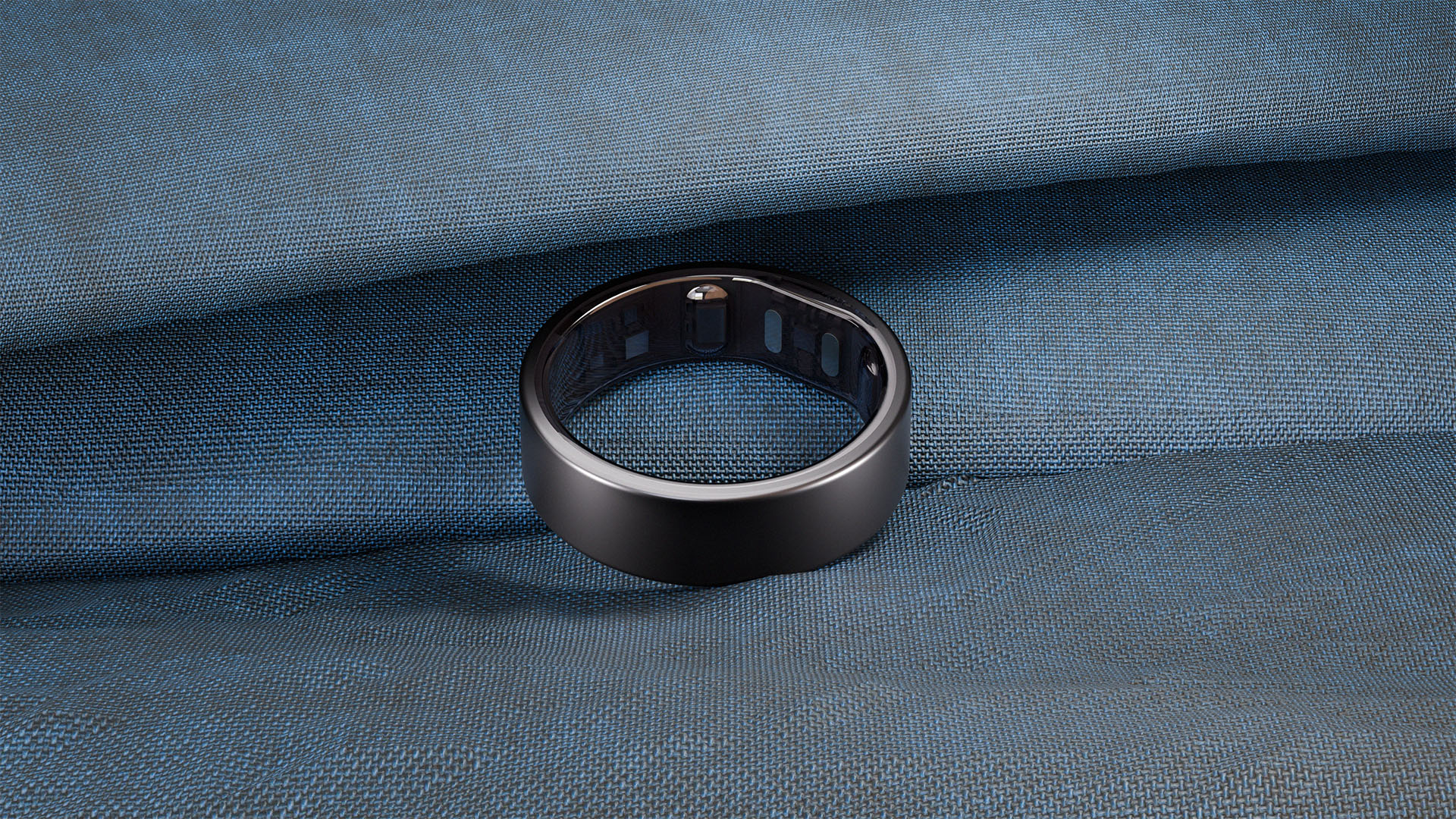 Black Reebok Smart Ring 3D render on dark fabric surface