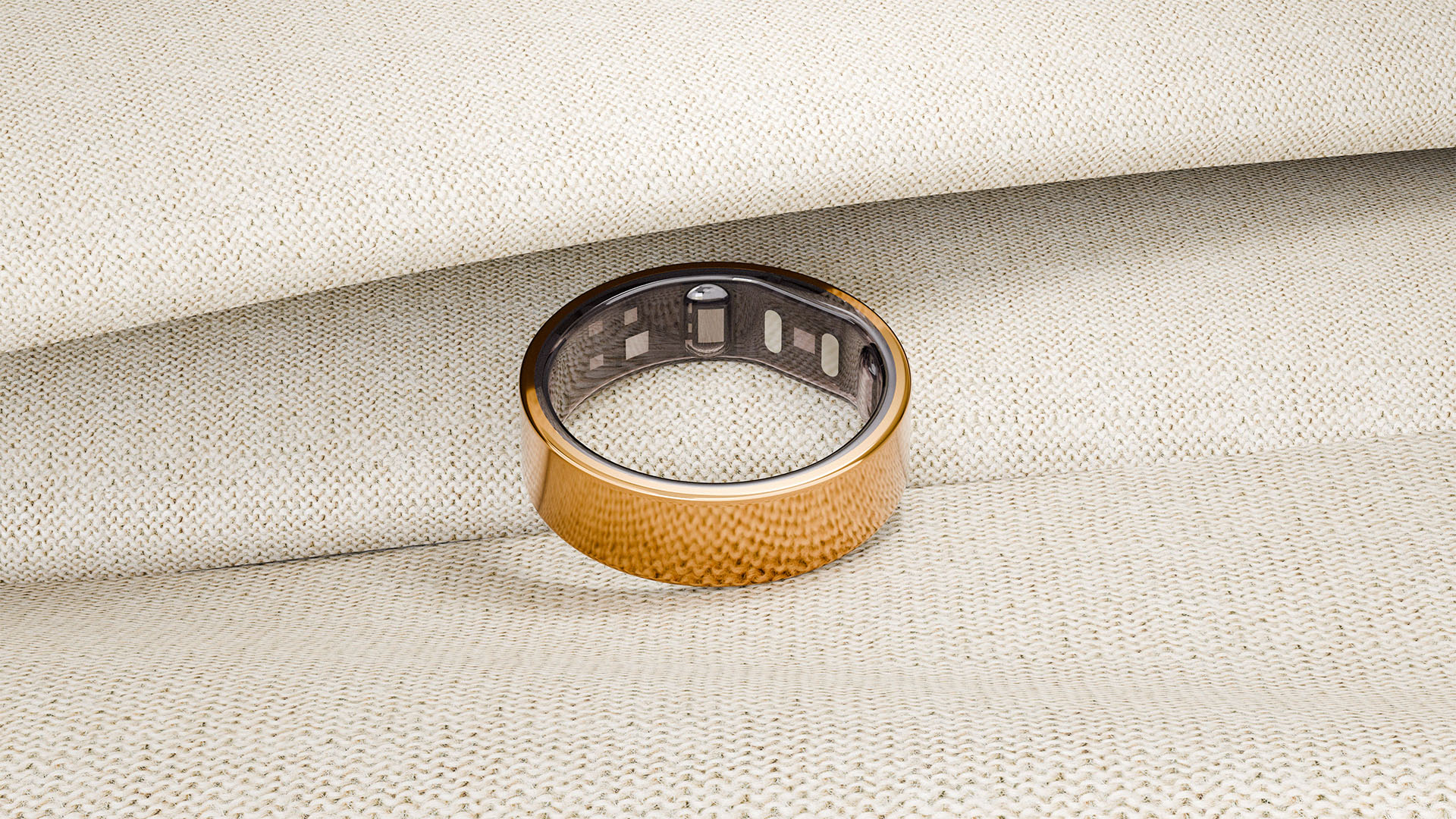 Gold Reebok Smart Ring 3D render on beige fabric surface